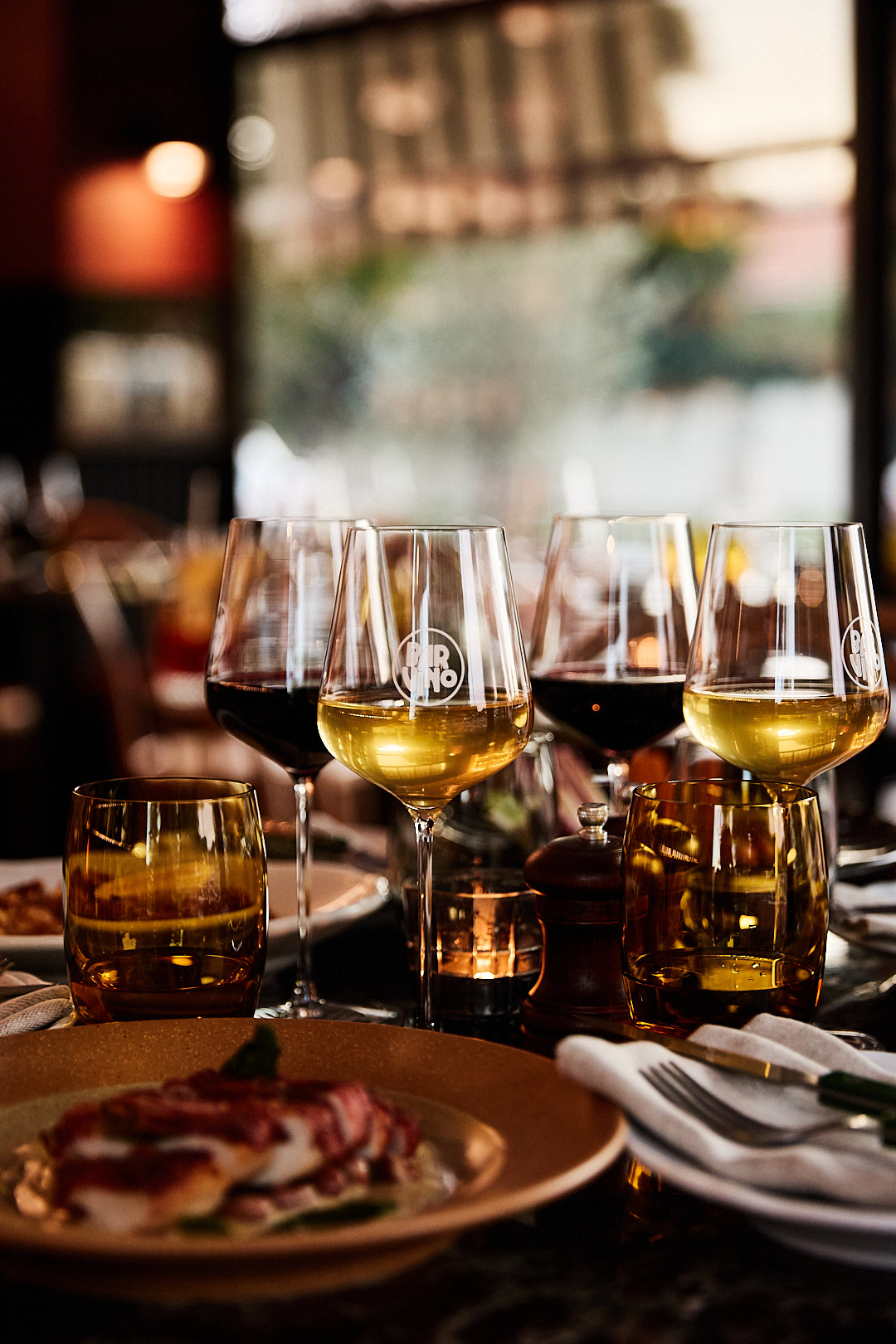 A full table of both red and white wine glasses and food at Bar Vino in Mount Lawley