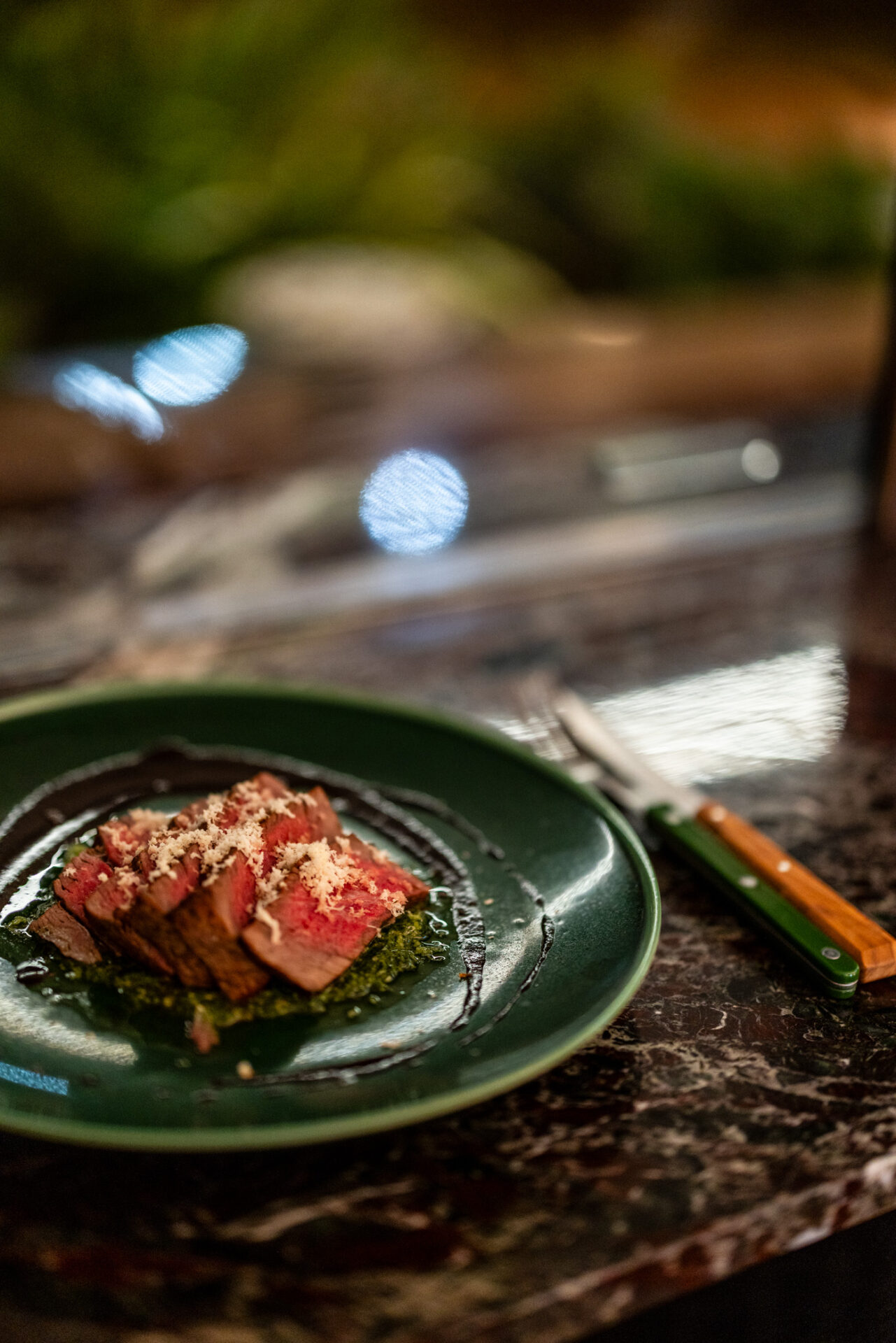 Perfectly cooked beef on dark green plate at Bar Vino