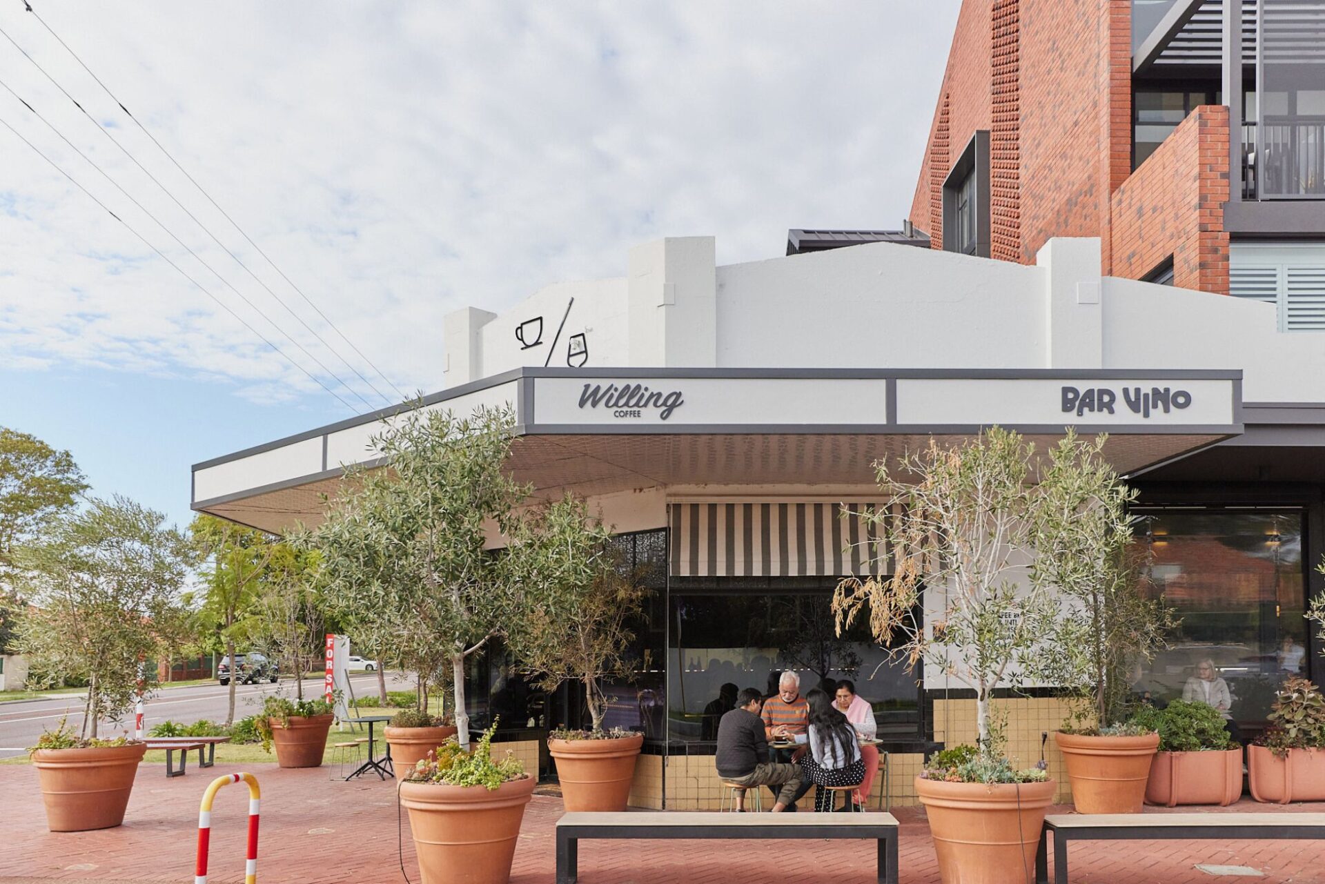 Exterior view of corner of Willing Coffee Mt Lawley with family out the front enjoying coffee