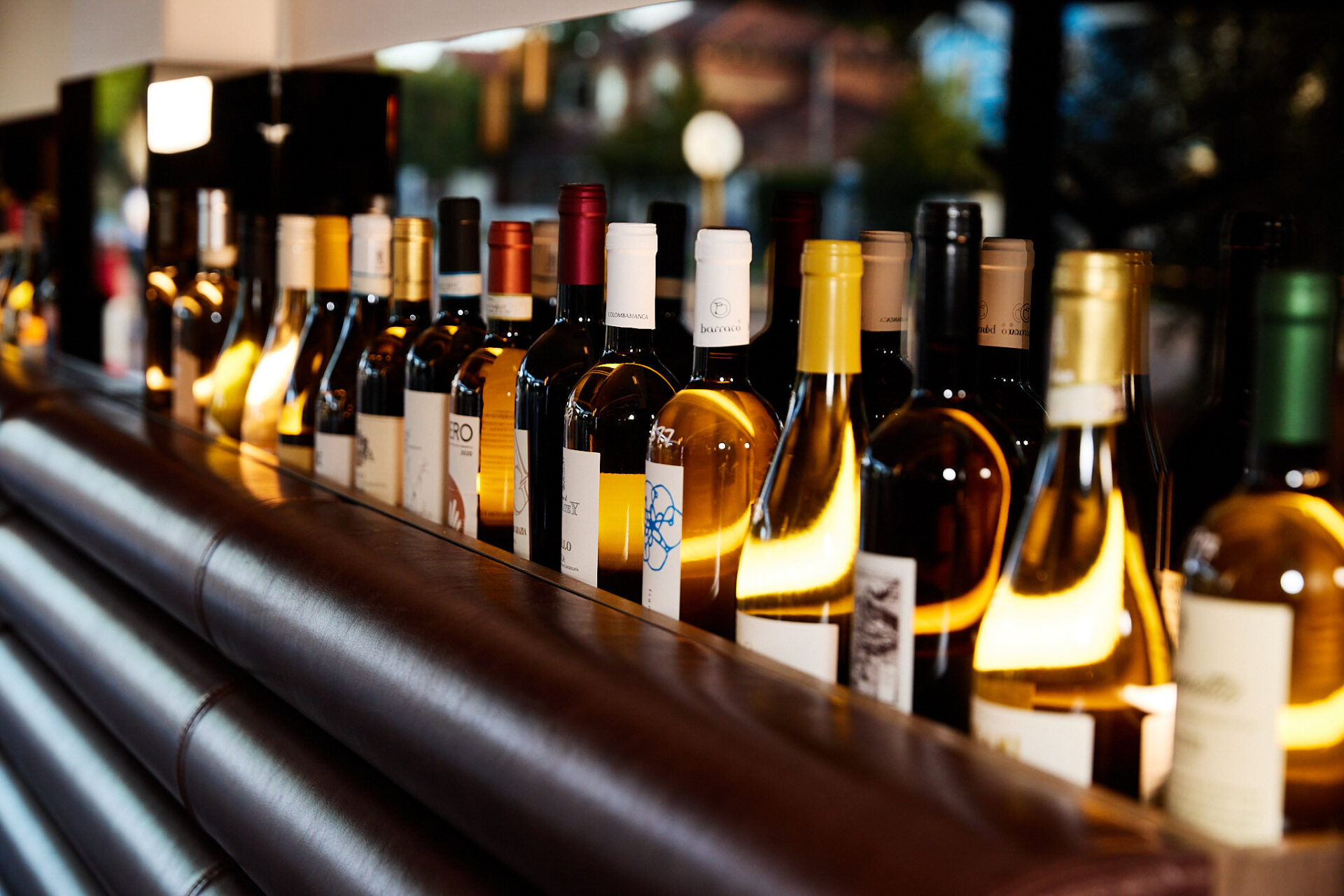 View of bar shelf with a row of wine bottles standing up