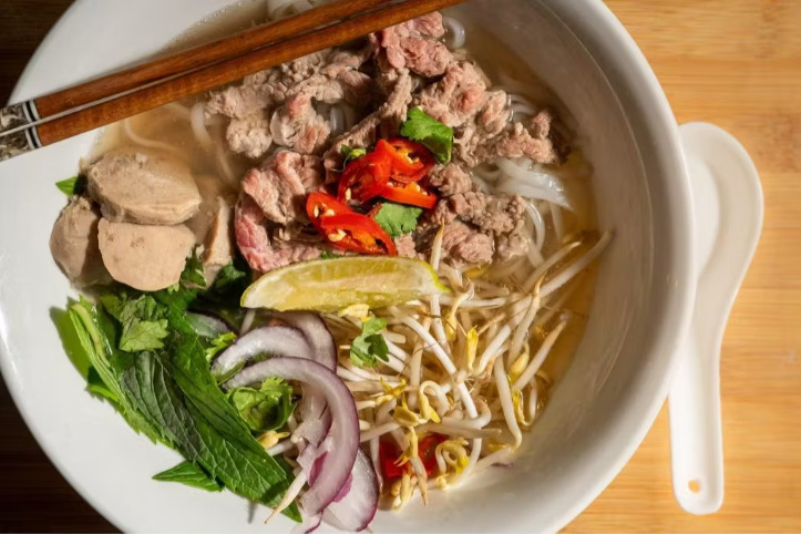 Bowl of Vietnamese noodles with chopsticks and spoon