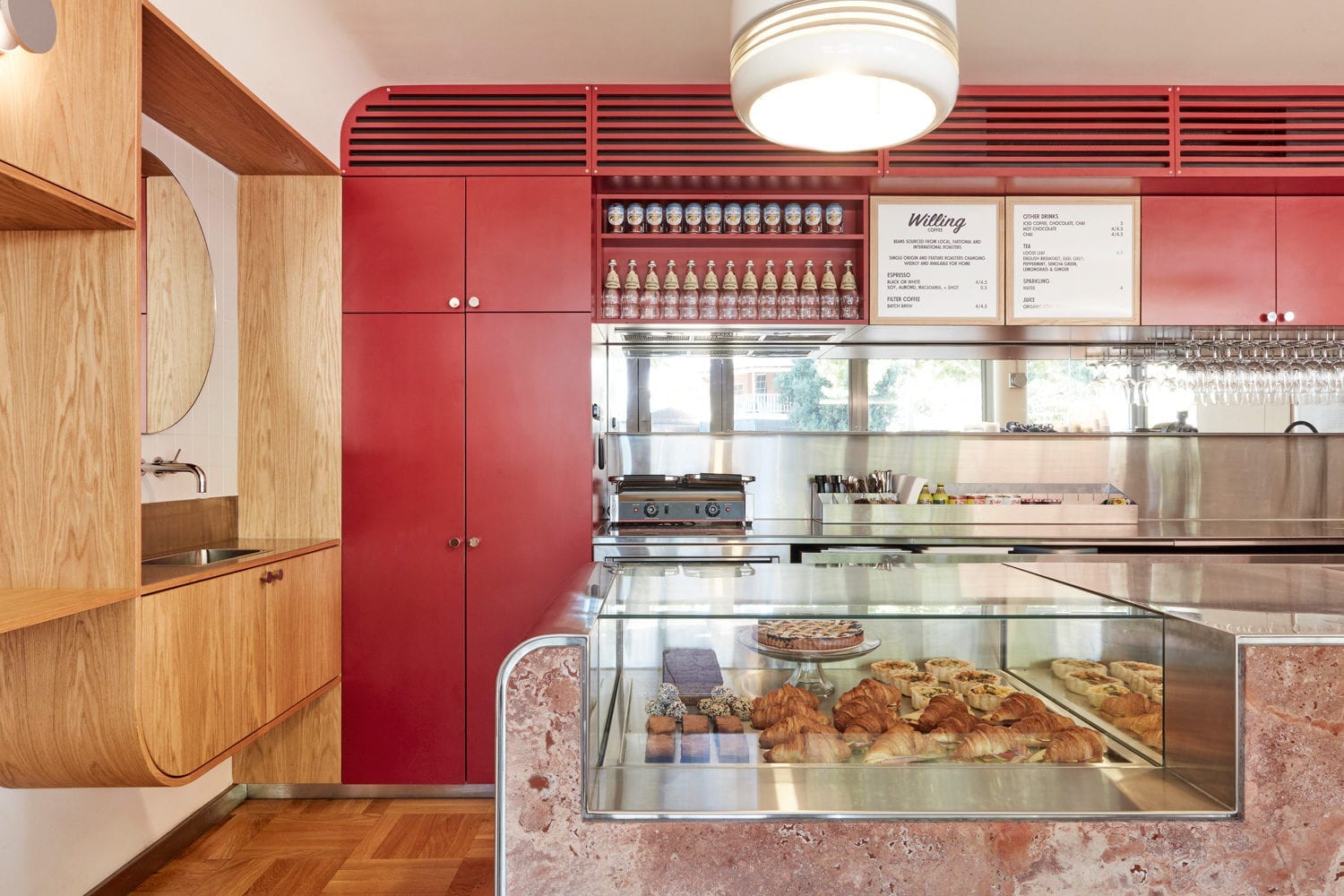 View of interior of a cafe overlooking a glass cabinet with baked goods.