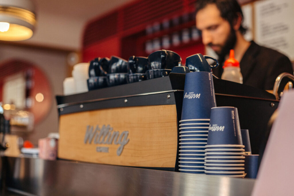 View from behind Willing coffee machine as barista prepares coffee