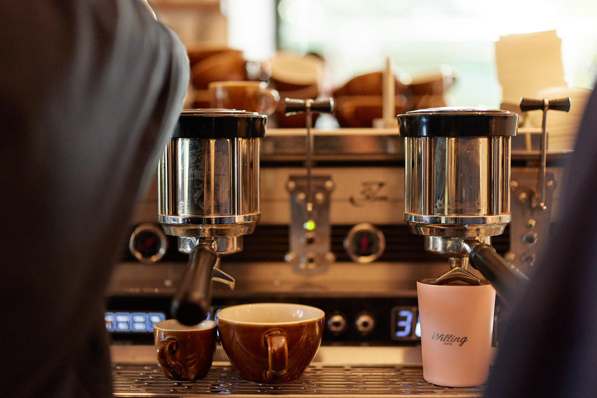 Willing Coffee coffee machines pouring coffee in a mug and small espresso cup.