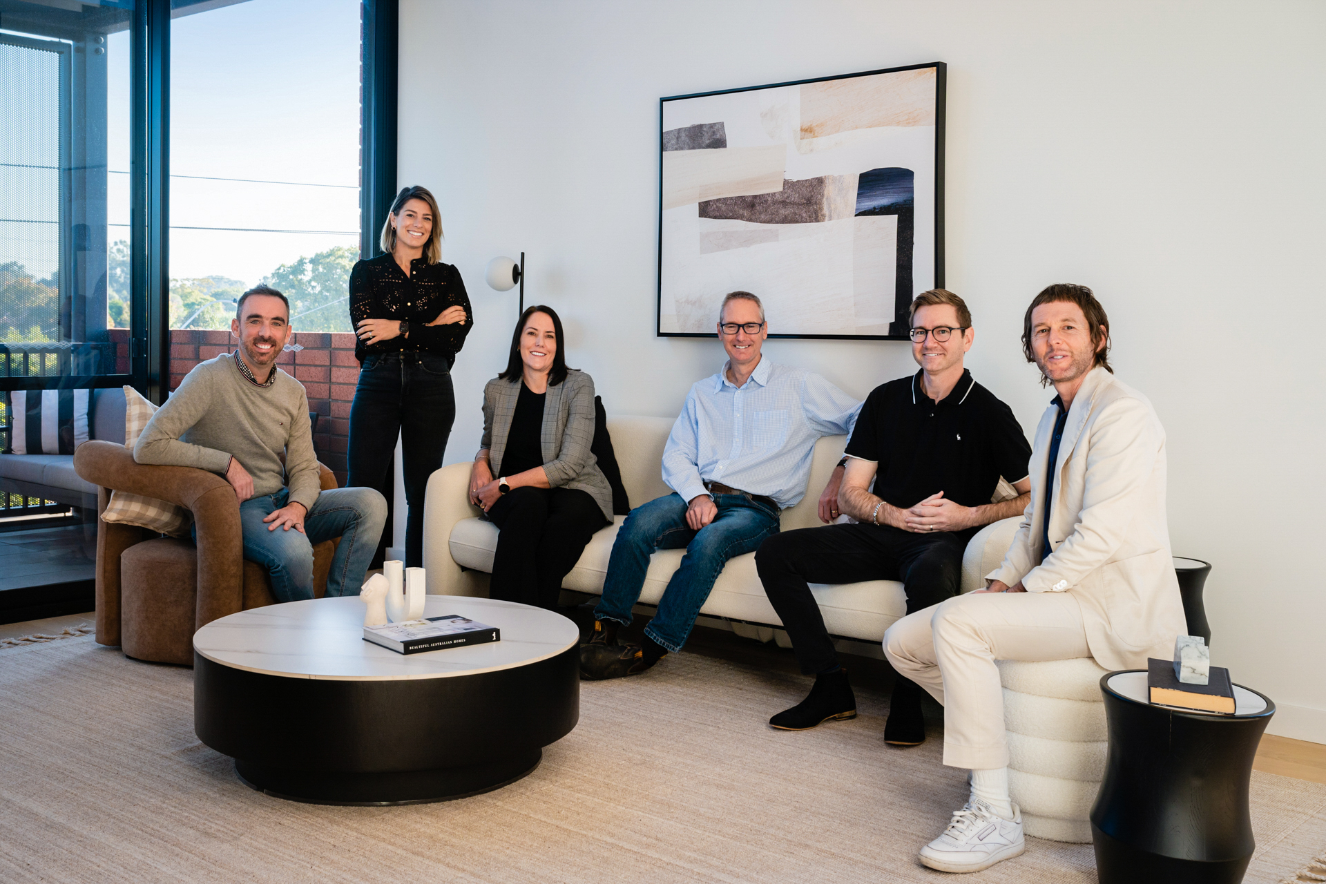 Willing Property Team having a meeting in a lounge room and all smiling at the camera