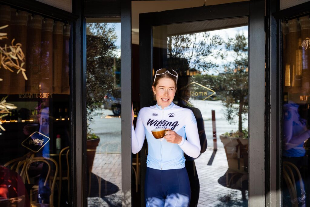 Photo of Local Cycling Star Cassia Boglio holding coffee at Willing Coffee in Mount Lawley